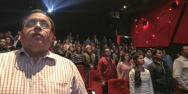 Audience members stand for the Indian national anthem before a movie starts at a cinema in New Delhi on December 4, 2016.