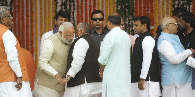 Prime Minister Narendra Modi interacting with former SP chief Mulayam Singh Yadav as well as former UP CM Akhilesh Yadav on the dais during the swearing-in ceremony at Lucknow's sprawling Smriti Upvan complex, on March 19, 2017 in Lucknow, India.