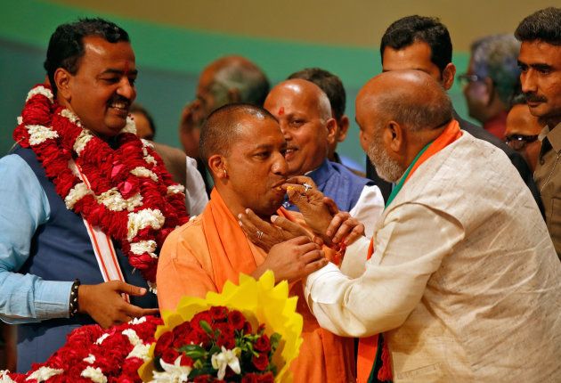 India?s ruling Bharatiya Janata Party (BJP) leader Yogi Adityanath (C) is offered sweets after he was elected as Chief Minister of India?s most populous state of Uttar Pradesh, during the party lawmakers' meeting in Lucknow, India March 18, 2017. REUTERS/Pawan Kumar