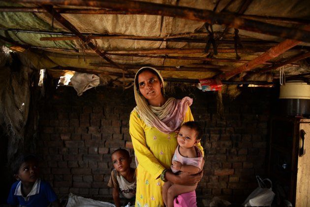 In this photograph taken on September 1, 2014, displaced Muslim villager Sanjida Ali holds a child as she speaks at a Muslim relief camp in Muzaffarnagar.