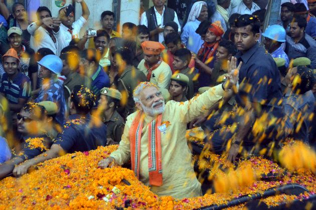 Prime Minister Narendra Modi waves to people during his road show on March 5, 2017 in Varanasi, India.