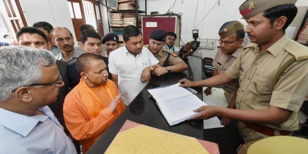 UP Chief Minister Yogi Adityanath speaks to a police personnel during a surprise visit at the Hazratganj police station in Lucknow on 23 March 2017.
