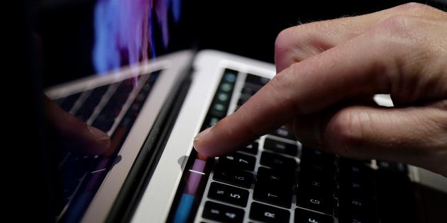 A guest looks at the Touch Bar on a MacBook