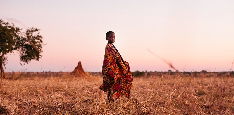 A young child walking through the fields in Zambia. Early morning and around dusk are times when mosquitoes are most active and people are at heightened risk of contracting malaria.