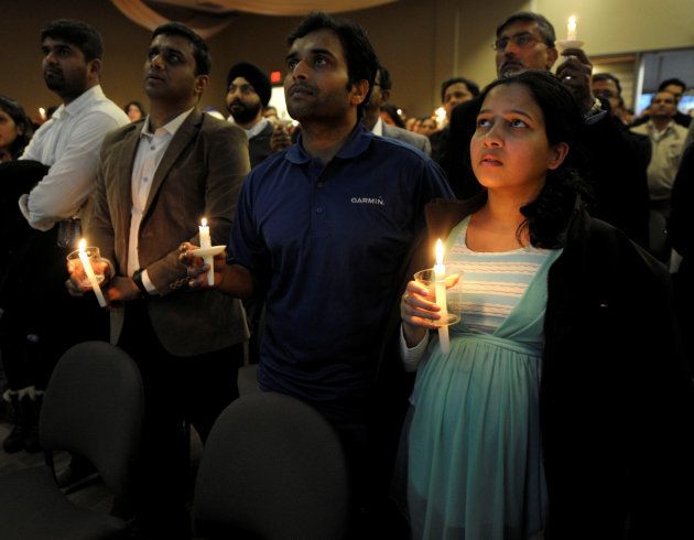 Alok Madasani, who was wounded in a bar shooting that killed Indian engineer Srinivas Kuchibhotla, sings during a candlelight vigil at a conference center in Olathe, Kansas, U.S., February 26, 2017. On right is Madasani's wife Reepthi Gangula. REUTERS/Dave Kaup