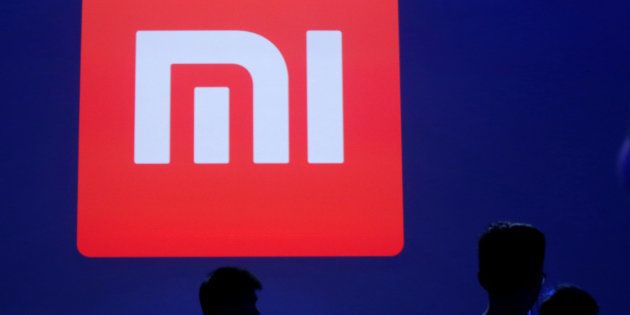 Attendants are silhouetted in front of Xiaomi's logo at a venue for the launch ceremony of Xiaomi's new smart phone Mi Max in Beijing, May 10, 2016. REUTERS/Kim Kyung-Hoon