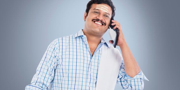 South Indian man talking on a mobile phone and smiling