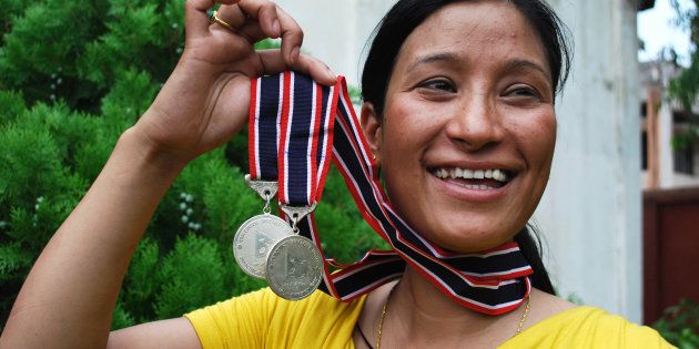 Indian mountaineer and mother of two children, Anshu Jamsenpa holds her medals received from the Nepalese government for summiting Mount Everest twice.