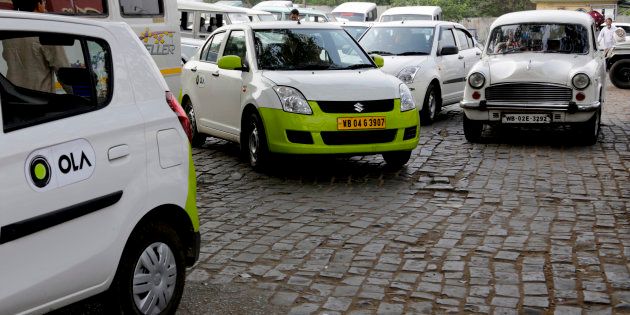 In this March 29, 2016 photo, Ola cabs, left, waiting for customers are parked next to other cars in Kolkata, India. Aiming to wrest control of Indias booming taxi market, two cab-hailing smartphone apps, Uber and Ola, are promising hundreds of millions in new investments while also facing off with one another in court. (AP Photo/ Bikas Das)