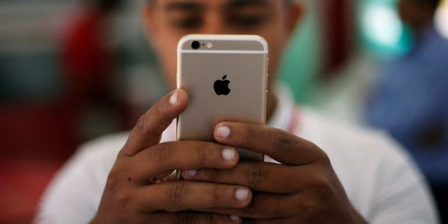 A salesman checks a customer's iPhone at a mobile phone store in New Delhi, India, July 27, 2016. REUTERS/Adnan Abidi