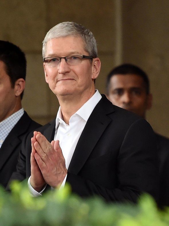 Apple chief executive Tim Cook greets onlookers as he leaves the Taj Mahal Palace hotel in Mumbai on May 18, 2016.