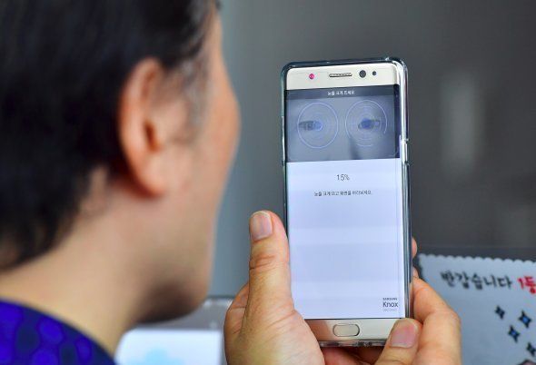 A South Korean man sets up iris recognition function on his replacement Samsung Galaxy Note7 smartphone at a telecommunications shop in Seoul on September 19, 2016. Samsung started on September 19 to provide users of its Galaxy Note 7 smartphone the first batch of replacements with new batteries, after a series of battery explosions prompted a major recall worldwide. / AFP / JUNG YEON-JE (Photo credit should read JUNG YEON-JE/AFP/Getty Images)