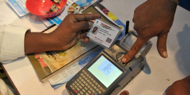 An Indian visitor gives a thumb impression to withdraw money from his bank account with his Aadhaar or Unique Identification (UID) card during a Digi Dhan Mela, held to promote digital payment, in Hyderabad on January 18, 2017.