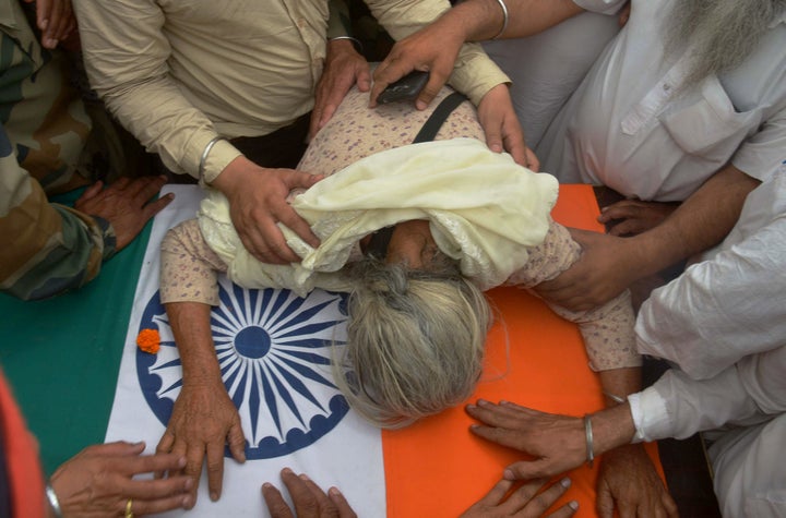 Gurinder Kaur, the mother of Indian Army soldier Paramjeet Singh cries over his coffin during his funeral at Vein Pein village, some 45kms from Amritsar on May 2, 2017. The Indian army accused Pakistan of killing two of its soldiers and mutilating their bodies in an 'unprovoked' rocket and mortar attack along the tense border which sparates the two countries. / AFP PHOTO / NARINDER NANU (Photo credit should read NARINDER NANU/AFP/Getty Images)