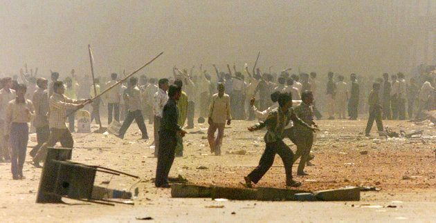 Indian Hindus riot in the smoke-shrouded streets of Ahmedabad, 2002.