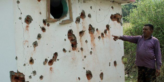 Jammu: A villagers points out damaged wall of a house after mortal shelling from Pakistan, at Jhanghar village area near the Line of Control (LoC) at Nowshera sector 145km about from Jammu on Sunday. PTI Photo