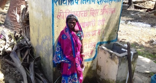 A village woman is standing in front of a newly constructed toilet at her home. (Photo by Mohd Imran Khan)