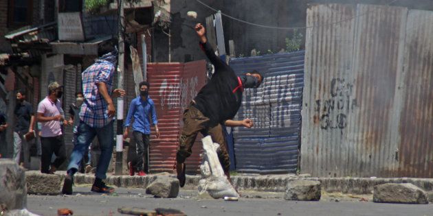 SRINAGAR, JAMMU AND KASHMIR, INDIA - 2017/05/27: A masked youth throwing stone towards government forces in Srinagar May 27, 2017 . Civilian was killed and dozens of others injured in Indian-controlled Kashmir following the killing of a top militant commander and his associate during a gunbattle with government forces. (Photo by Umer Asif/Pacific Press/LightRocket via Getty Images)
