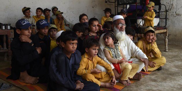 In this photograph taken on May 20, 2017, Pakistani father Gulzar Khan, 57, who has 36 children from his three wives, sits with his children as he speaks during an interview with AFP at his house in the northwestern town of Bannu.