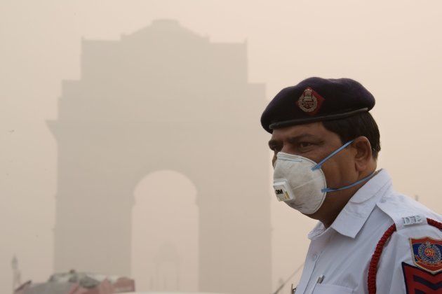 This photo taken on November 9, 2017 shows an Indian policeman wearing a protection mask as he works near India Gate amid heavy smog in New Delhi. India's capital has reeled under dense smog that has disrupted air and railway services and forced residents to stay indoors or wear protection when they venture outside. The city's poor, by contrast, are often unable to buy suitable protection and unaware of the health dangers of the toxic air. / AFP PHOTO / DOMINIQUE FAGET / To go with the photo package INDIA-POLLUTION-HEALTH (Photo credit should read DOMINIQUE FAGET/AFP/Getty Images)