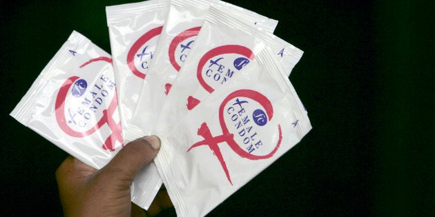 A sex worker holds packets of female condoms during an HIV/AIDS awareness campaign at a red-light area in the northeastern Indian city of Siliguri July 6, 2007. The number of people living with HIV/AIDS in India is 2.47 million, less than half of previous official estimates, according to new U.N.-backed government estimates released on Friday during the launch of the country's new $2.8-billion National AIDS Control Program. REUTERS/Rupak De Chowdhuri (INDIA)