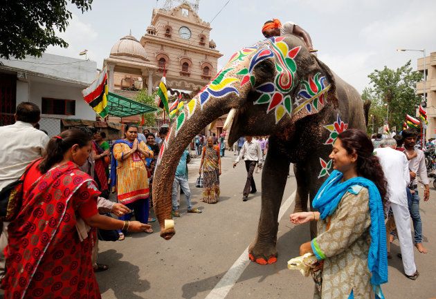 Devotees give money to a decorated elephant outside the Jagannath temple on the eve of the annual Rath Yatra in Ahmedabad, India, June 24, 2017. REUTERS/Amit Dave