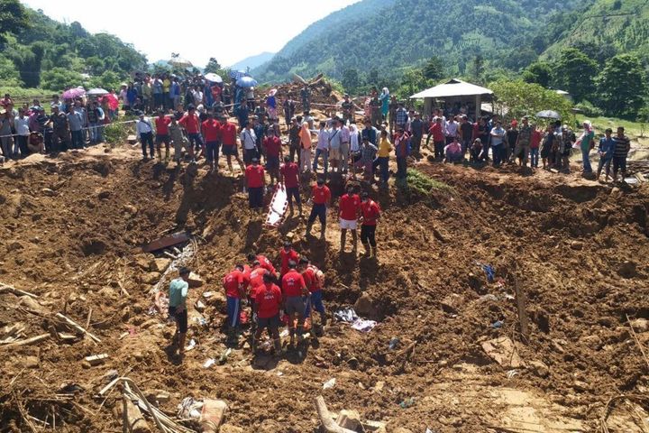 Indian National Disaster Response Force personnel take part in a rescue operation at the site of a landslide in Laptap village in the Papum Pare district of the state of Arunachal Pradesh on July 12, 2017. At least five people were killed and 10 missing July 11 after a massive landslide buried homes in a remote village in northeast India, a disaster management official said. An avalanche of mud and rock struck the village after weeks of heavy rain in Papum Pare district in the Himalayan state of Arunachal Pradesh along the border with China. / AFP PHOTO / STR (Photo credit should read STR/AFP/Getty Images)