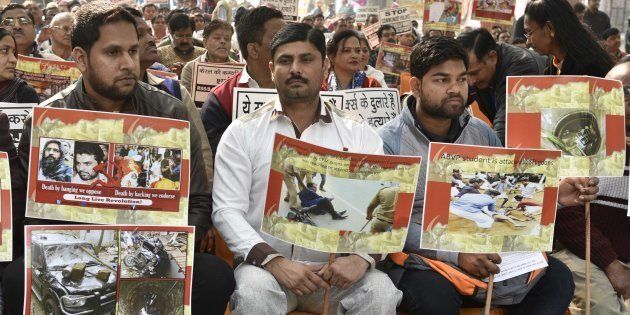 Supporters and workers holding placard during the protest against brutal attack on RSS-BJP workers in Kerala, at Kerala Bhavan on January 24, 2017 in New Delhi.