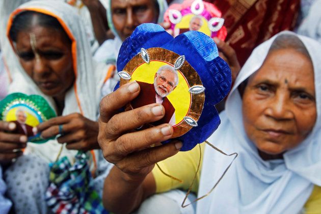 Widows, who have been abandoned by their families, show rakhis with a picture of Indian Prime Minister Narendra Modi on them.