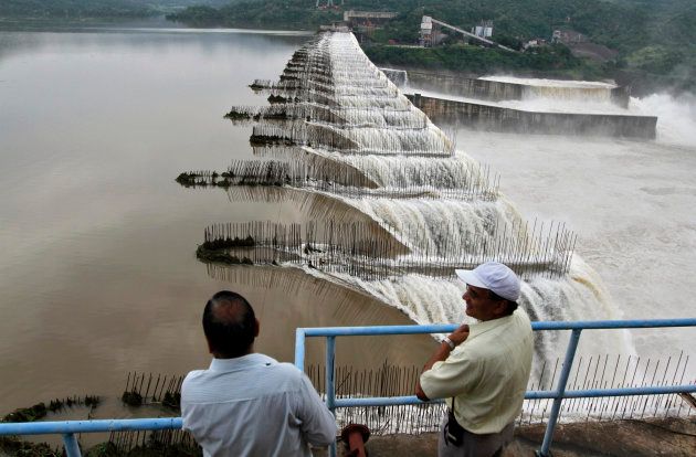 Indian officials look at the overflowing Sardar Sarovar Narmada dam in Kavadia, 194 km south of Ahmedabad, August 29, 2011.
