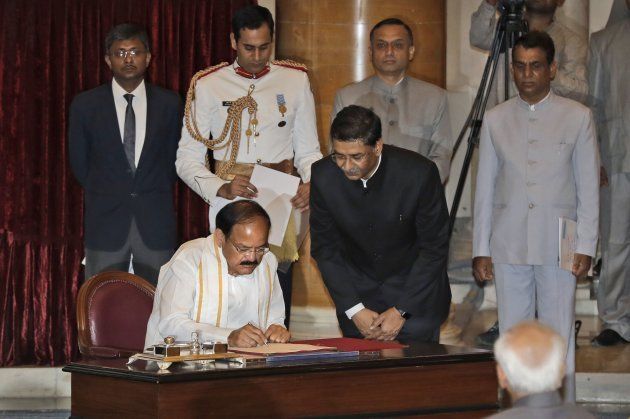 Venkaiah Naidu (L) signs the official book after being sworn in as India's new vice president as outgoing Vice President Hamid Ansari (bottom R) watches at the presidential palace in New Delhi on August 11, 2017. Naidu, who served in Indian Prime Minister Narendra Modi's cabinet, became India's 13th vice president. / AFP PHOTO / POOL / Manish Swarup (Photo credit should read MANISH SWARUP/AFP/Getty Images)