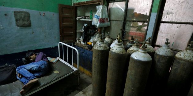 A man sleeps in a room containing oxygen tanks in the Baba Raghav Das hospital in Gorakhpur district, India August 13, 2017. REUTERS/Cathal McNaughton