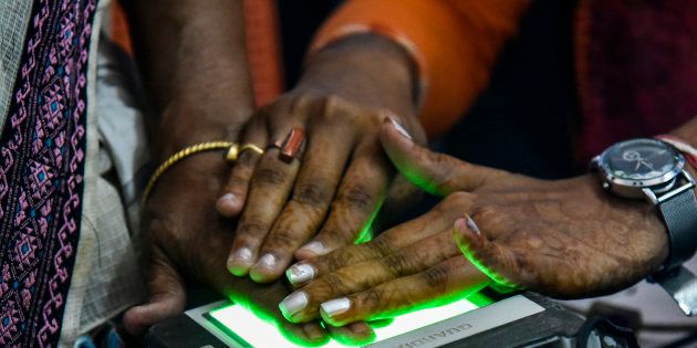 Women scanning fingerprints as an Aadhaar registration process.