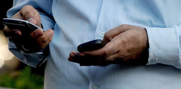An Indian officegoer checks a text message on his mobile phone in Mumbai on September 27, 2011.