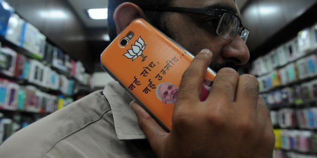 An Indian shopkeeper speaks on his mobile phone adorned with a cover featuring Bharatiya Janata Party's Narendra Modi in Mumbai on April 2, 2014.