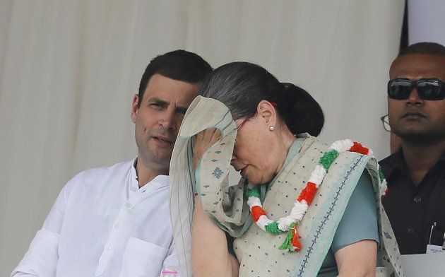 India's Congress party president Sonia Gandhi wipes her sweat as party's vice-president Rahul Gandhi (L) watches during a farmers rally at Ramlila ground in New Delhi, India, September 20, 2015.