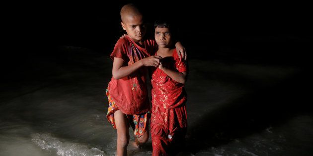 Rohingya refugee sisters, who just arrived under the cover of darkness by wooden boats from Myanmar, hug each other as they try to find their parents at Shah Porir Dwip, in Teknaf, near Cox's Bazar in Bangladesh, September 29, 2017. Picture taken September 29, 2017. REUTERS/Damir Sagolj