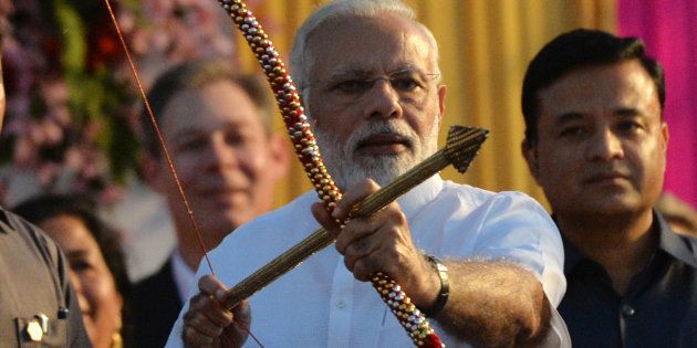 Indian Prime Minister Narendra Modi holds a bow and arrow at an event ahead of the burning of the effigy of the Hindu demon Ravana.