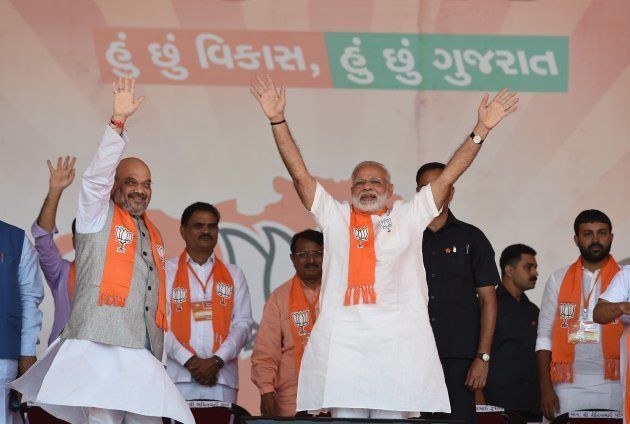 Indian Prime Minister Narendra Modi (C/R) and Bhartiya Janta Party (BJP) President Amitbhai Shah (2nd L), wave to the supporters on their arrival at Gujarat Gaurav Mahasamellan at Bhaat village on the outskirts of Ahmedabad on October 16, 2017.