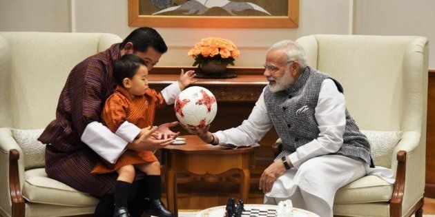 Modi presents the Prince of Bhutan with an official football from the FIFA U-17 World Cup.