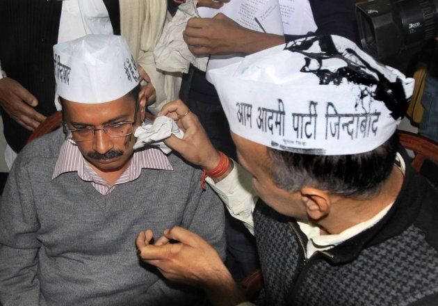 Aam Aadmi Party (AAP) leader Manish Sisodia cleaning the face of Arvind Kejriwal after a man who claimed to be Nachiketa Walnekar threw black ink at AAPs leaders during the press conference of Aam Aadmi Party at Constitution Club on November 18, 2013 in New Delhi.