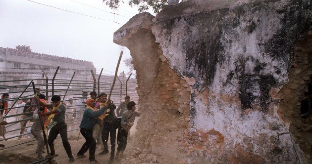 Hindu fundamentalists attack the wall of the 16th century Babri Masjid Mosque with iron rods in the city of Ayodhya.