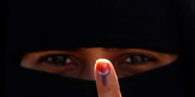 An Indian Muslim woman displays her finger after casting her vote in the first phase polling of Gujarat assembly elections on December 13, 2012 in Surat, India.