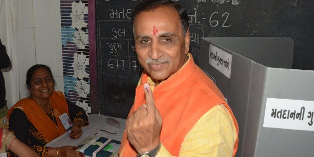 Gujarat state Chief Minister Vijay Rupani shows his inked finger after casting his ballot during the first phase of Vidhan Sabha elections of Gujarat state at Rajkot, some 220 kms from Ahmedabad on December 9, 2017.