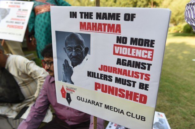 Indian journalist participates in a peace protest near the statue of Mahatma Gandhi at Gandhi Ashram in Ahmedabad on October 2, 2017.