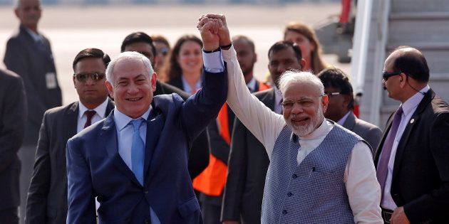 Israeli Prime Minister Benjamin Netanyahu and his Indian counterpart Narendra Modi raise their arms upon Netanyahu's arrival at Air Force Station Palam in New Delhi, India, January 14, 2018.