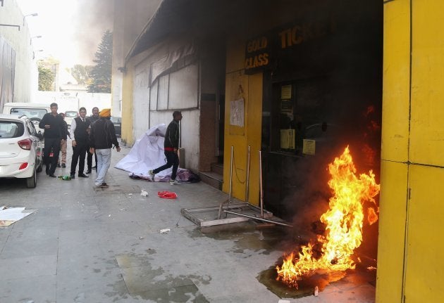 Smoke and fire emerges from a cinema ticket booth after an attack by activists in protest against the Bollywood film 'Padmaavat' in Jammu on January 24, 2018.