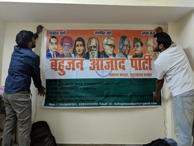 Members of the party hold up a poster they just printed and brought from Bihar.
