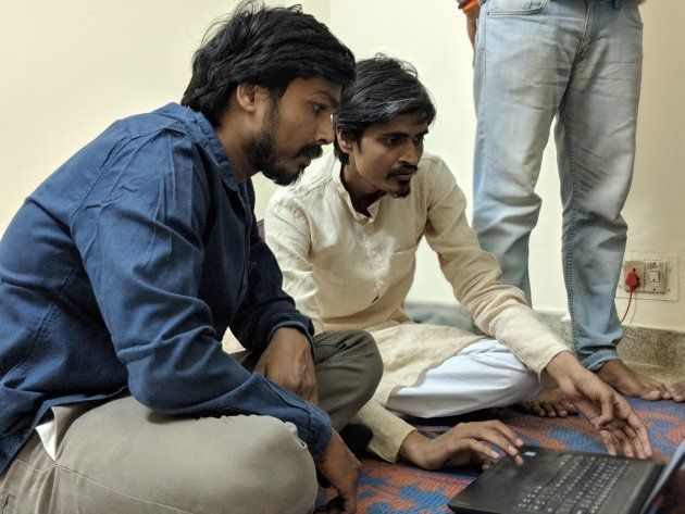 Akhilesh and Vikrant huddle over a laptop as they create the party's website.