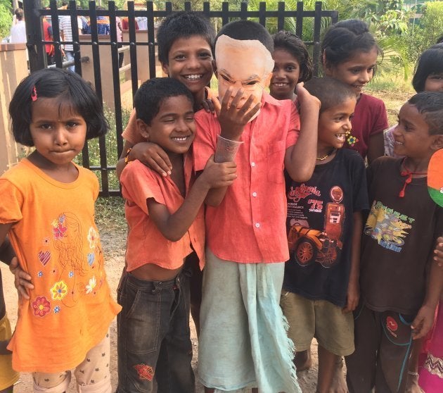 Children play with a Narendra Modi mask near a BJP rally in Udupi on May 1, 2018